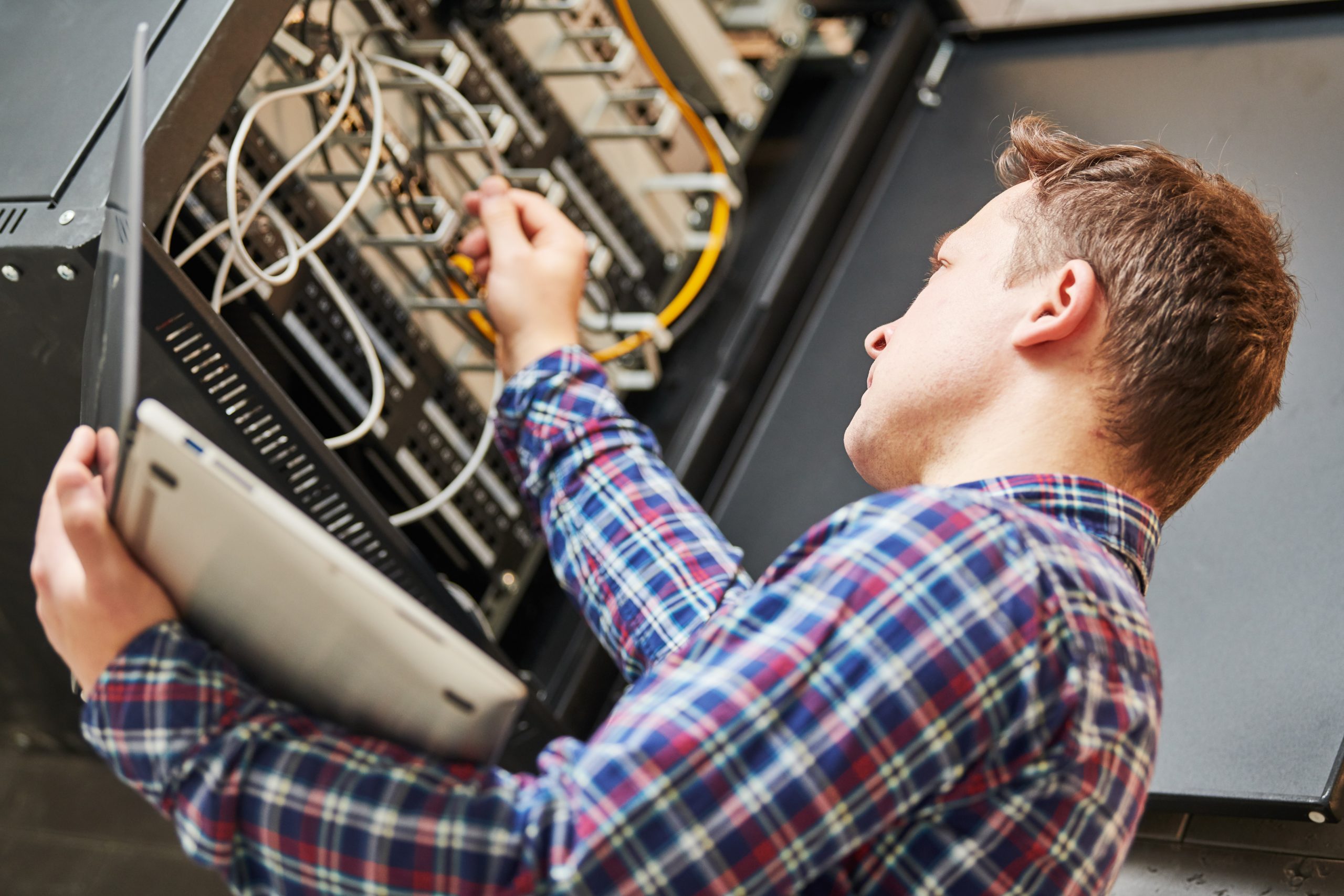 network engineer admin works with server equipment Tecnicien d'IT en train de faire le point sûr les serveurs. Expertise financière et informatique, Evernext.
